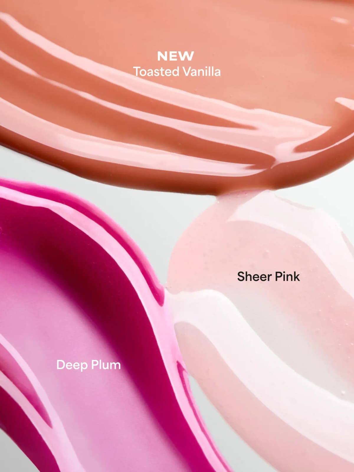 Glossy smears of Toasted Vanilla, Sheer Pink and Deep Plum gloss balm shades side by side