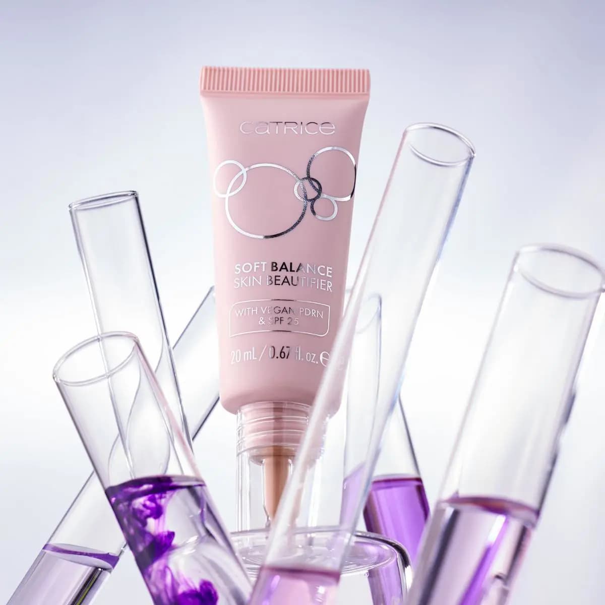Pink Soft Balance Skin Beautifier tube with vegan PDRN and SPF 25 among purple-filled test tubes