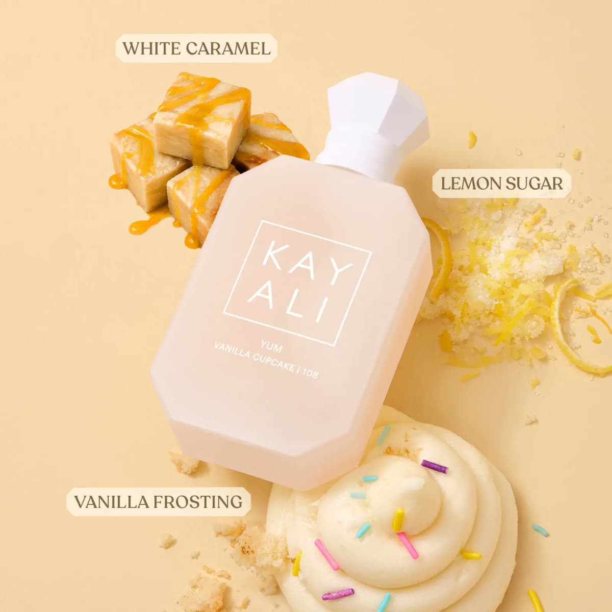 Bottle lying among white caramel fudge, lemon zest sugar and a swirl of sprinkle-topped vanilla frosting