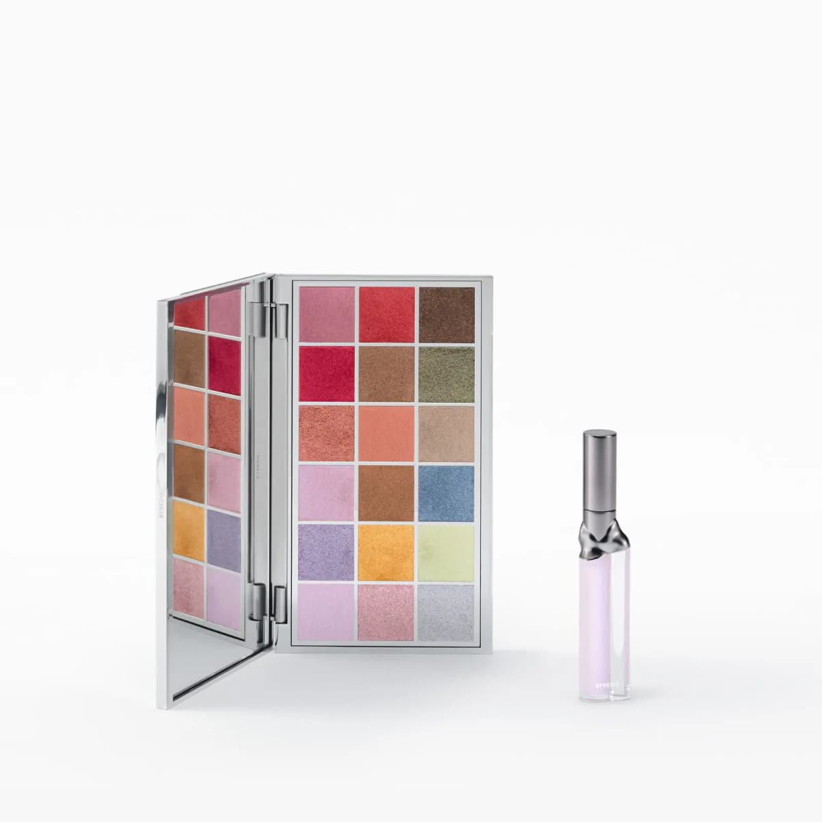 Palette open upright beside a clear lip gloss tube with a sculpted silver collar and lilac formula