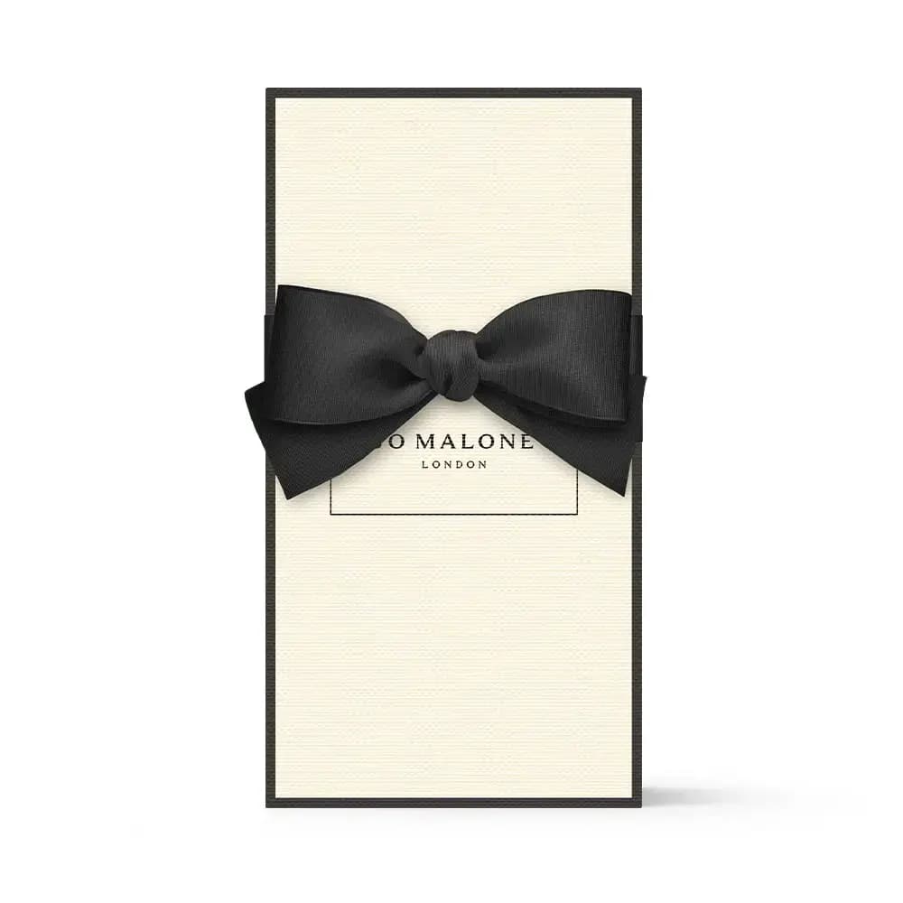 Cream Jo Malone London gift box with a black grosgrain ribbon bow tied across the front