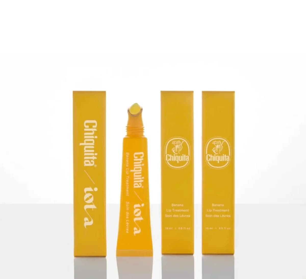 Lineup of the uncapped yellow tube between three yellow boxes showing Chiquita / iota and Chiquita logo sides