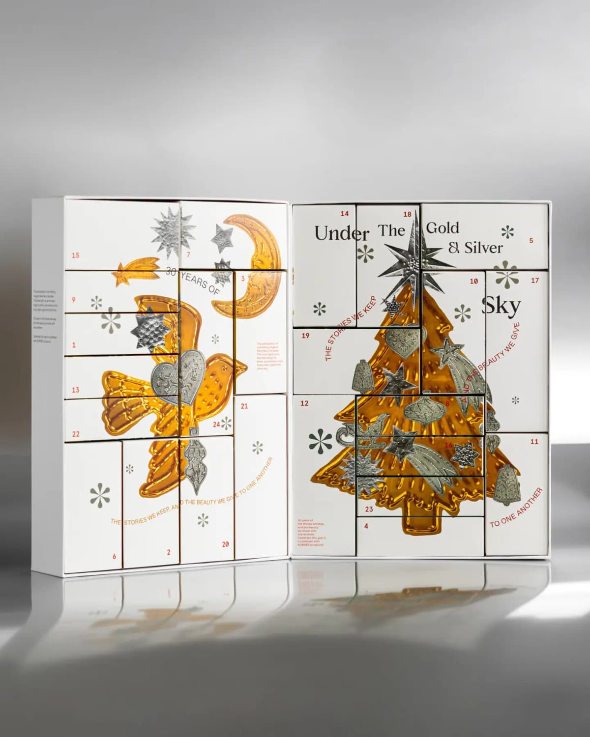 Open KORRES Advent Calendar with numbered white boxes forming a gold dove, moon and tree with embossed silver ornaments