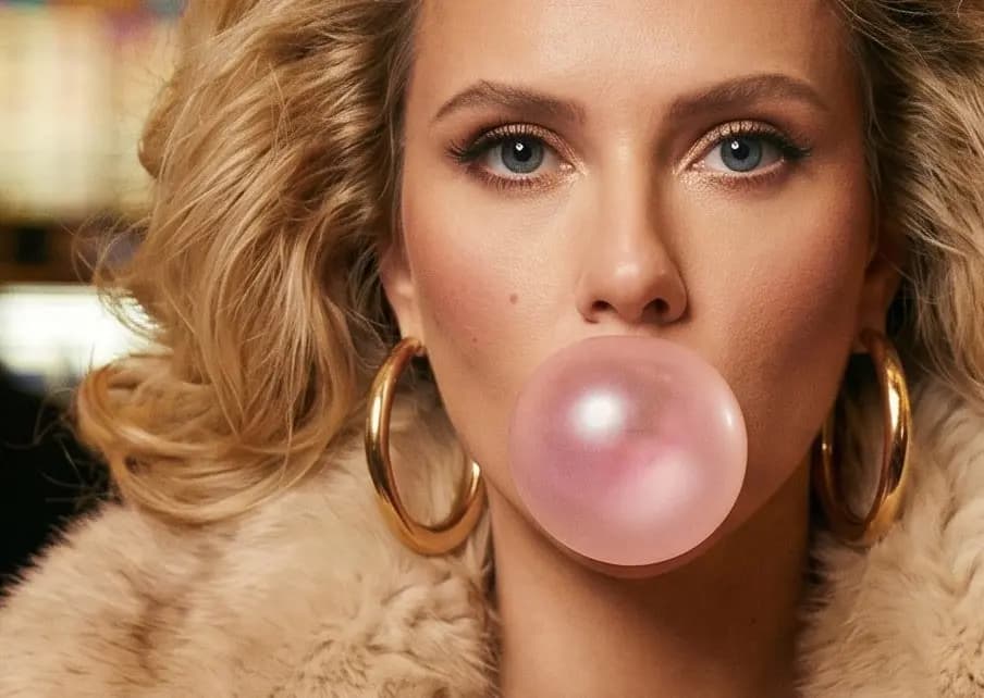 ānti Plastic Love campaign image: a woman with gold hoop earrings and a fur collar blowing a large pink bubblegum bubble