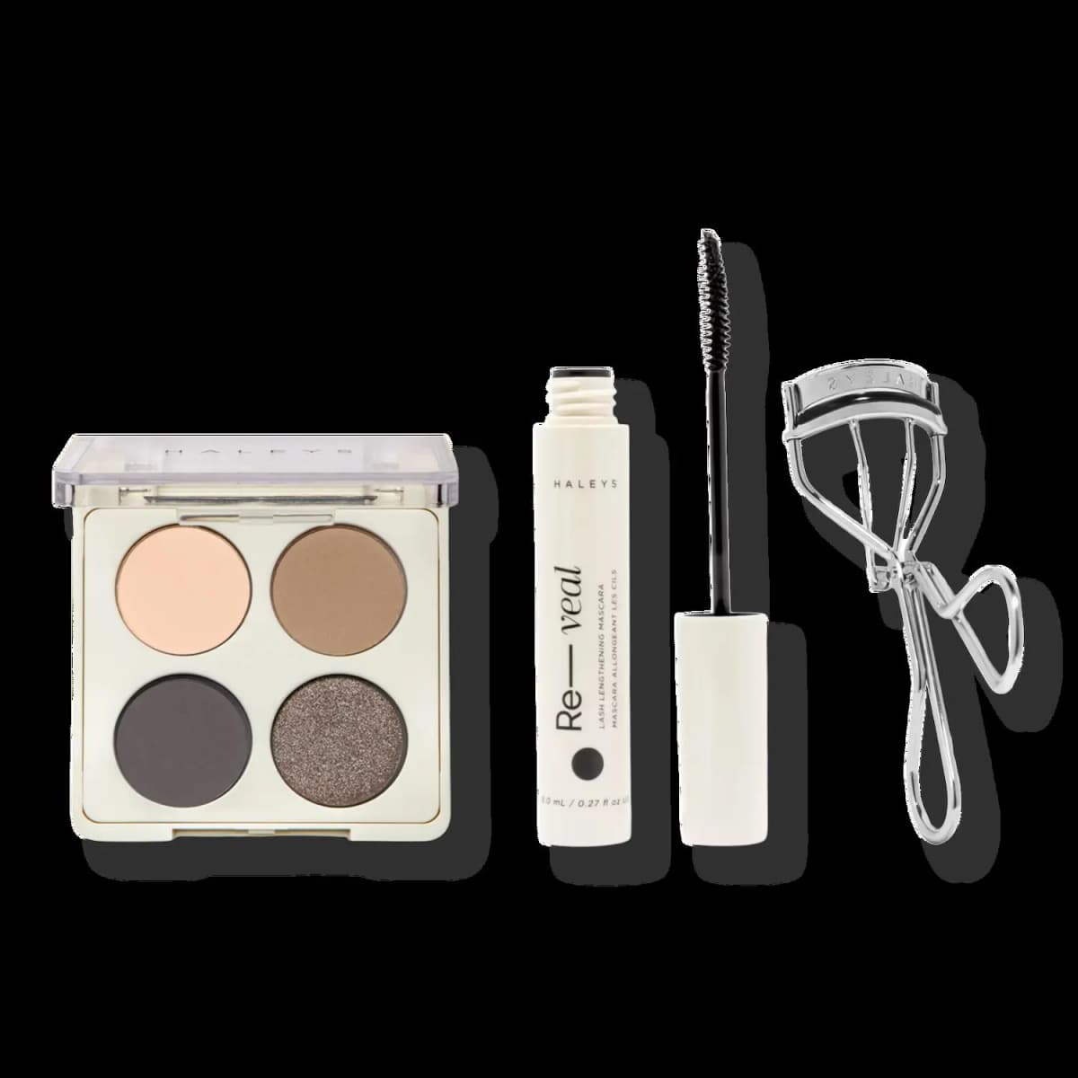 Set version with peach, tan, charcoal and smoky bronze glitter eyeshadow quad beside Re-veal mascara and silver curler