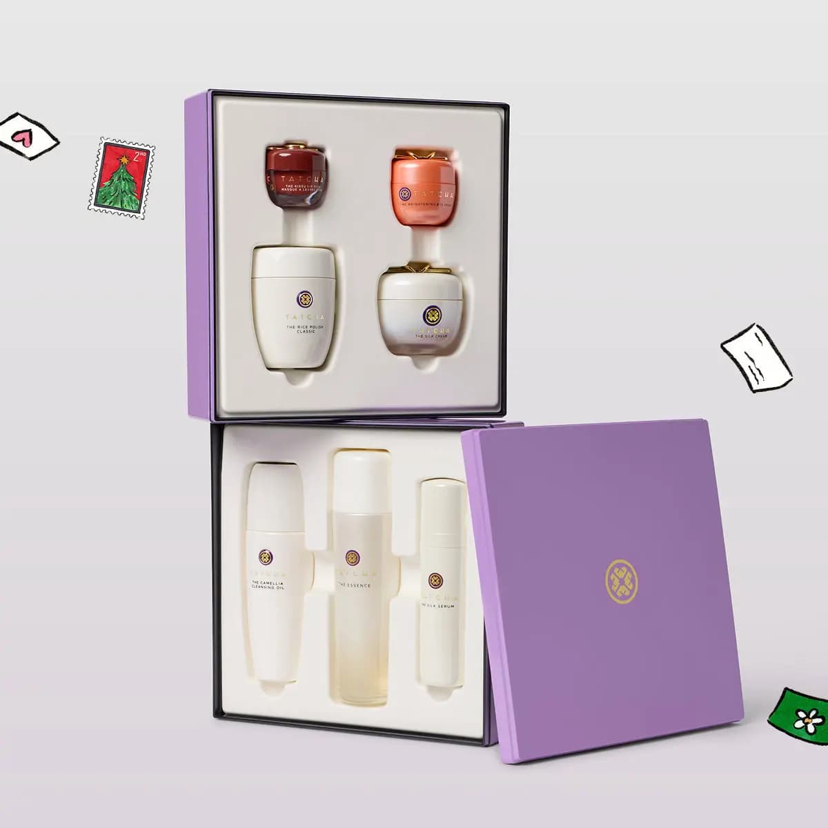 Lilac Tatcha box open to show The Rice Polish, The Silk Cream, The Essence, The Silk Serum and a lip mask in white trays