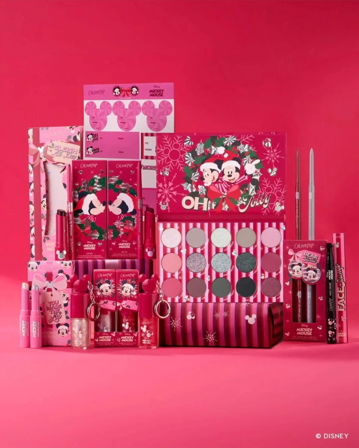 ColourPop Disney A Very Mickey Christmas collection with palette, lip kits, glosses and liners on a pink-red backdrop