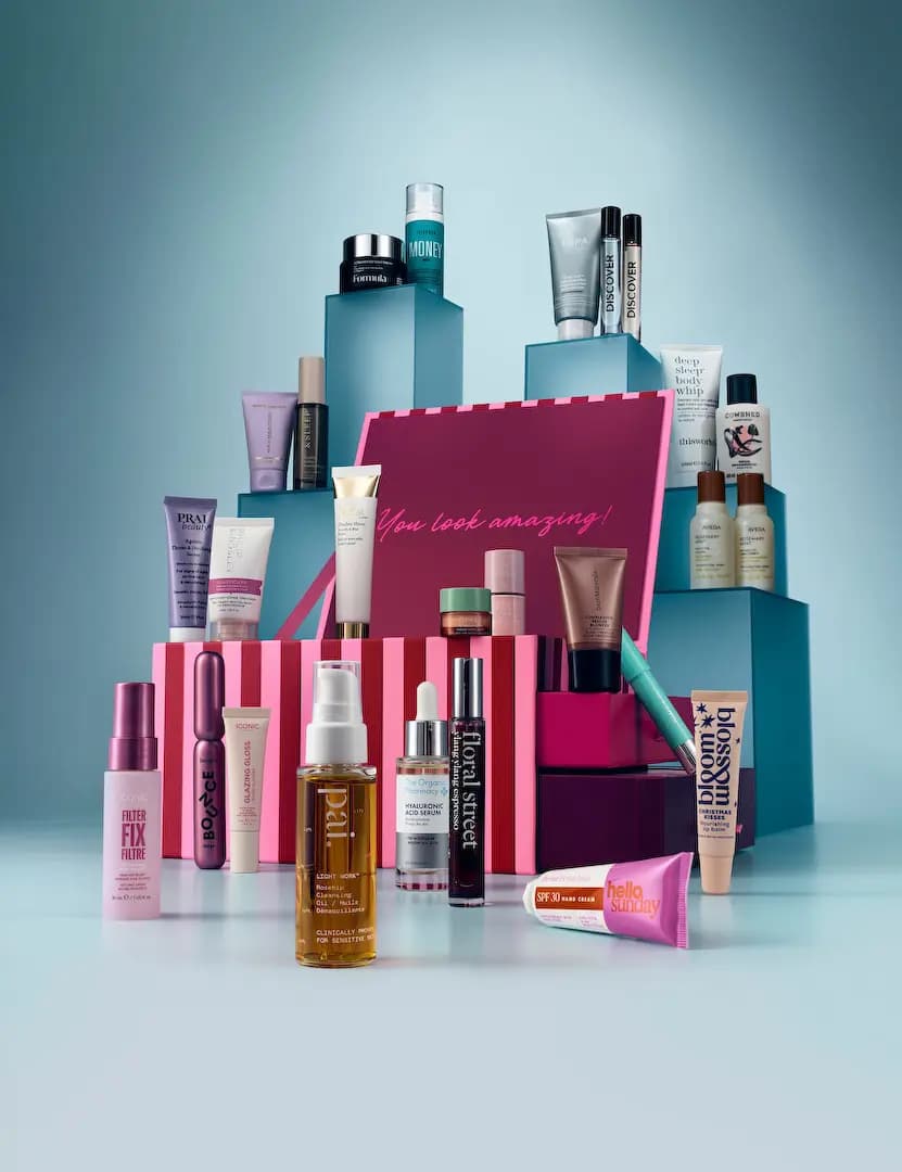 M&S Beauty Advent Calendar 2026 products by Pai, Formula, ESPA and Aveda arranged on teal plinths around a pink striped box