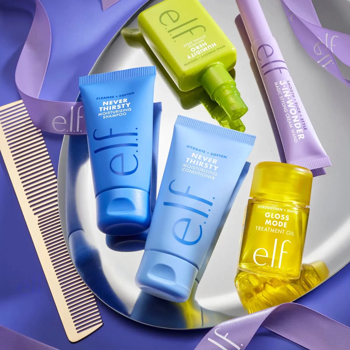 Never Thirsty minis on a mirror tray with Humidity Hero spray, 3-in-Wonder wand, Gloss Mode oil, comb and ribbon