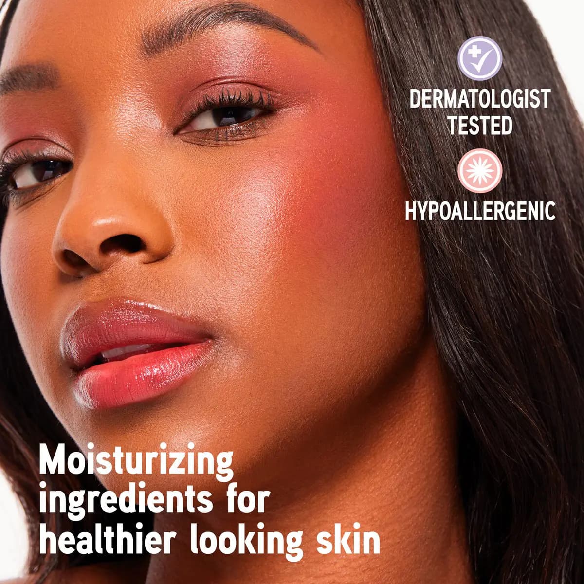 Deep-skinned model with vibrant coral-red blush across cheeks, dermatologist tested and hypoallergenic labels on right