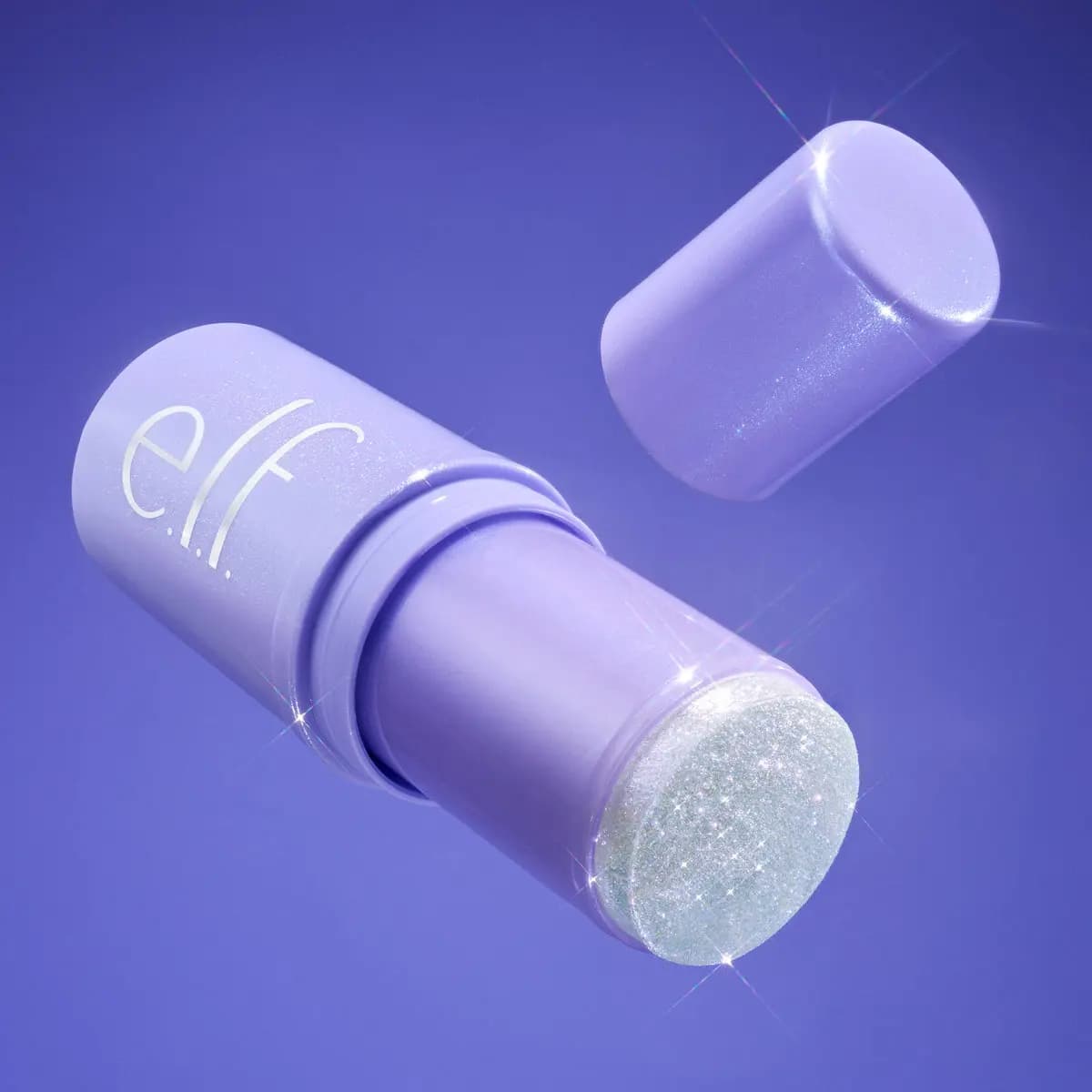 Lilac e.l.f. hair stick with its cap floating above, revealing a sparkling glitter bullet, on purple background.