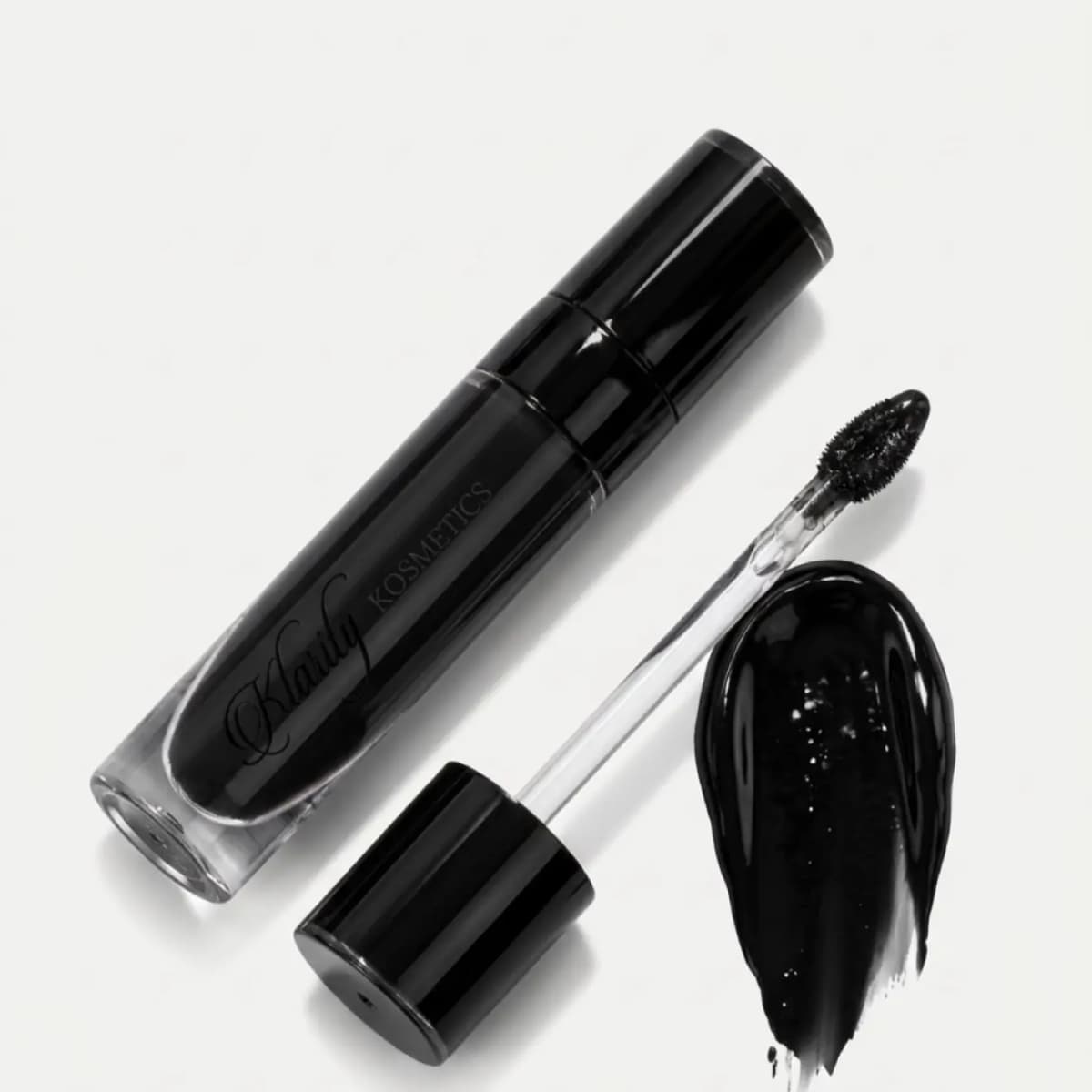Klarity Kosmetics Ace of Spades Lip Gloss tube in glossy black beside its doe-foot wand and a shiny ultra black swatch
