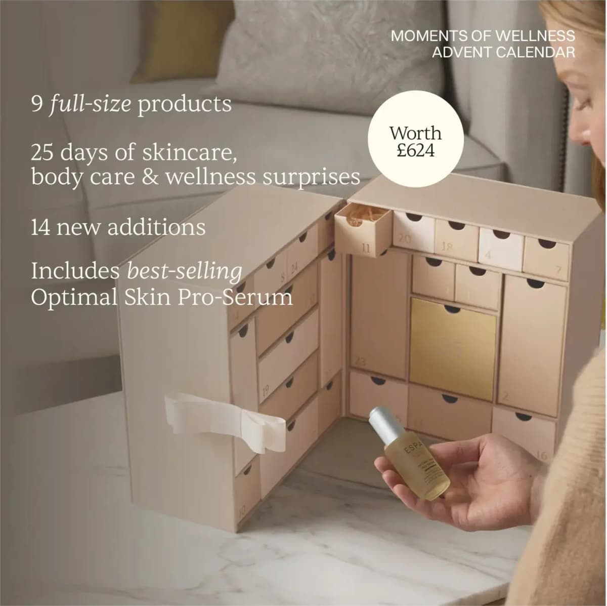 Hand holding Optimal Skin Pro-Serum by the open calendar, text: 9 full-size products, 14 new additions, worth £624