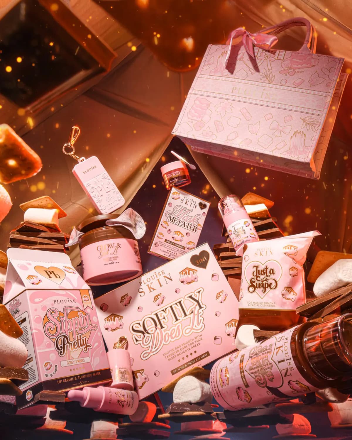 Gooey S'mores P.Louise Skin products, including Softly Does It and Sippin Pretty, with a pink tote and marshmallows