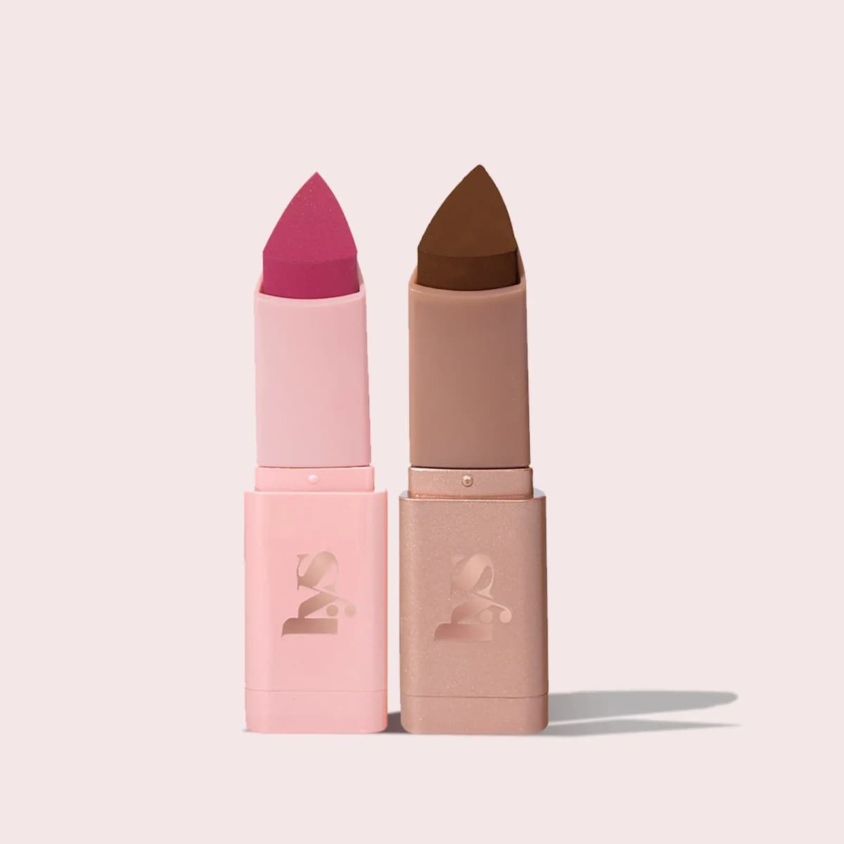 Two mini sticks side by side: a berry-pink blush in a pink case and a deep brown bronzer in a shimmery beige case