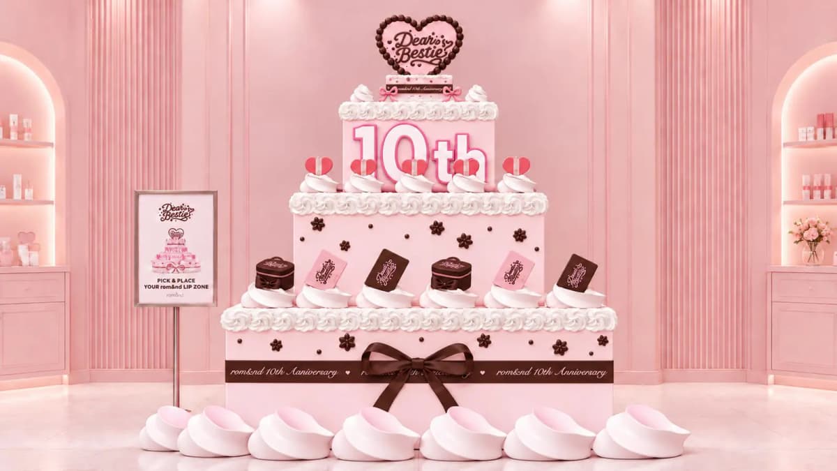 Giant pink tiered cake display marked 10th and rom&nd 10th Anniversary, with Dear Bestie heart topper and product cutouts