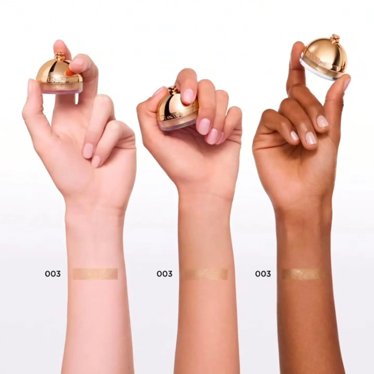 Three hands of light, medium and deep skin tones holding the gold dome compact, each with a 003 gold highlighter swatch