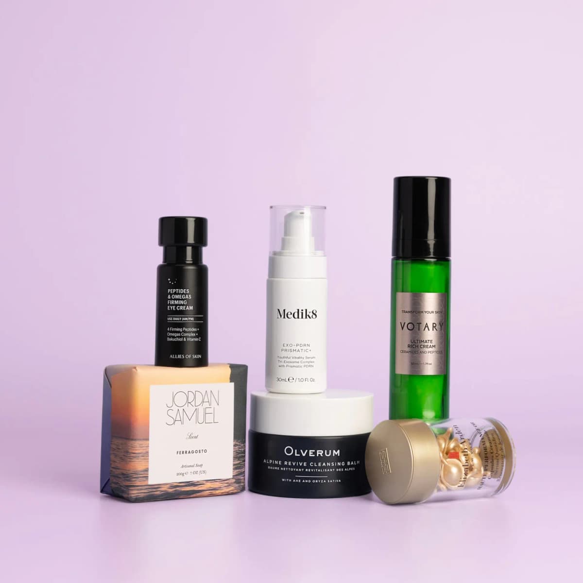 Medik8, Votary, Olverum, Jordan Samuel, Allies of Skin and Elizabeth Arden products stacked on a lilac background