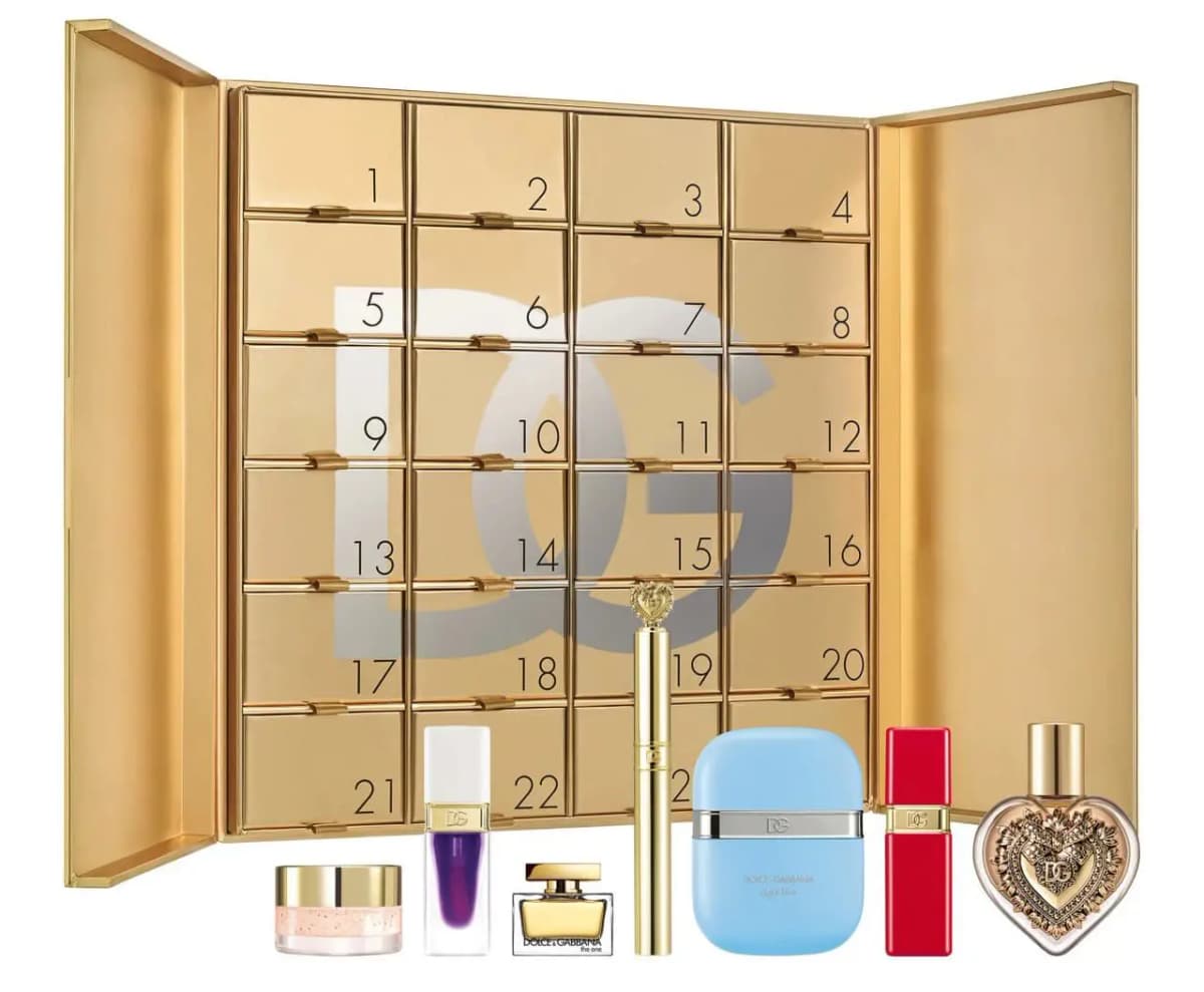 Open gold book-style Dolce&Gabbana advent calendar with 24 numbered drawers and DG monogram, fragrance
