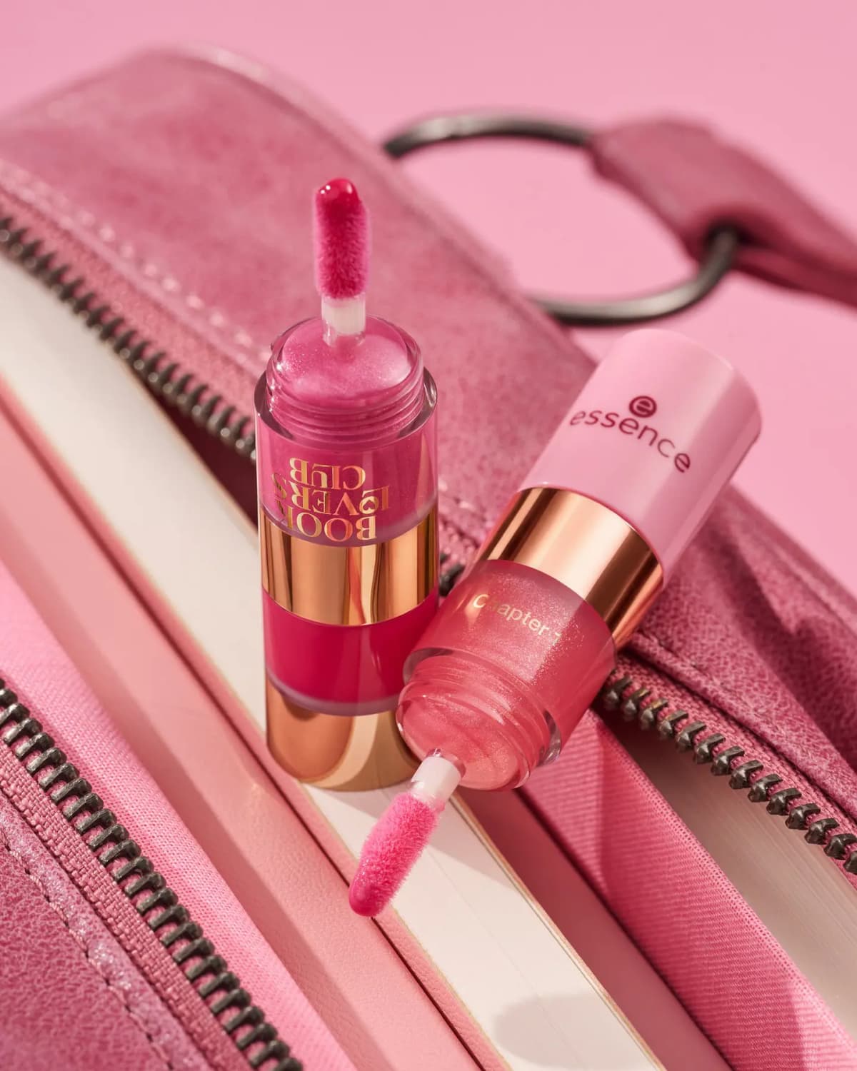 Essence Book Lovers Club Trend Edition lip gloss, two shimmery pink tubes with doe-foot wands on a pink zipped bag
