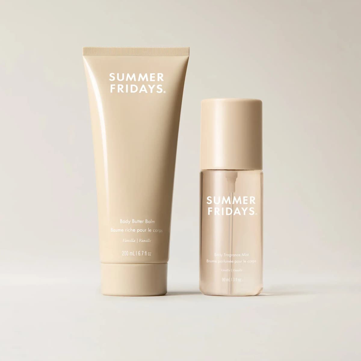Vanilla Body Butter Balm tube and Body Fragrance Mist bottle in matching beige, standing side by side on a cream backdrop.