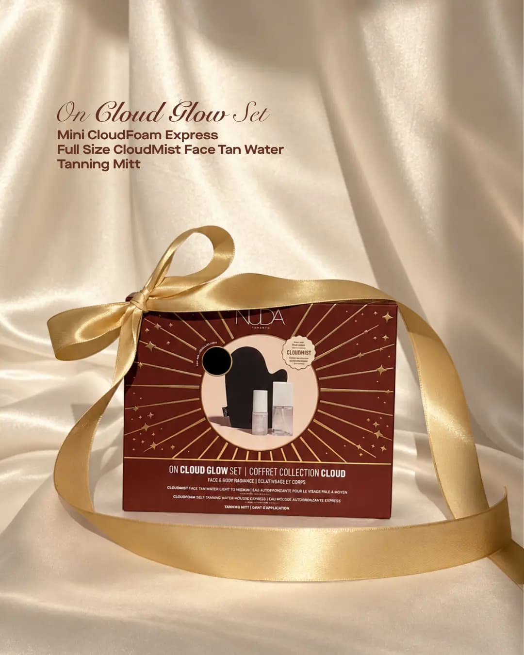 NUDA On Cloud Glow Set box tied with gold ribbon, showing a black tanning mitt, CloudFoam Express and CloudMist.