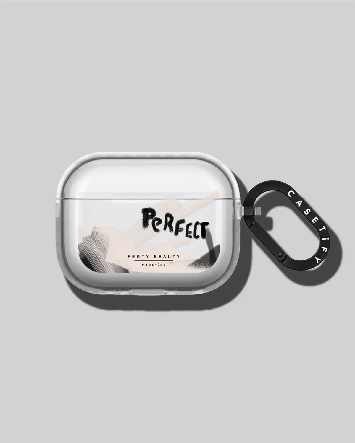 Clear earbuds case printed with black "Perfect" lettering and blush strokes, with a black CASETiFY carabiner