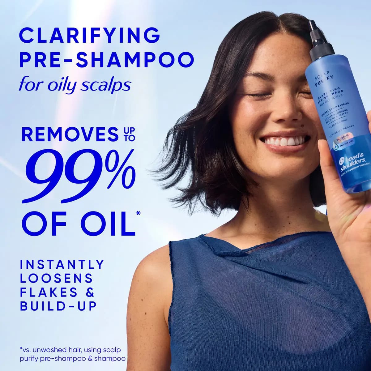 Smiling woman with a dark bob holds the blue pre-shampoo to her face beside text claiming it removes up to 99% of oil