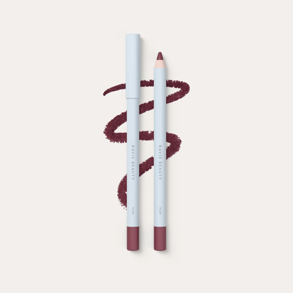 Ravie Beauty lip liner in Plum, two light blue pencils alongside a deep berry brown squiggle swatch.