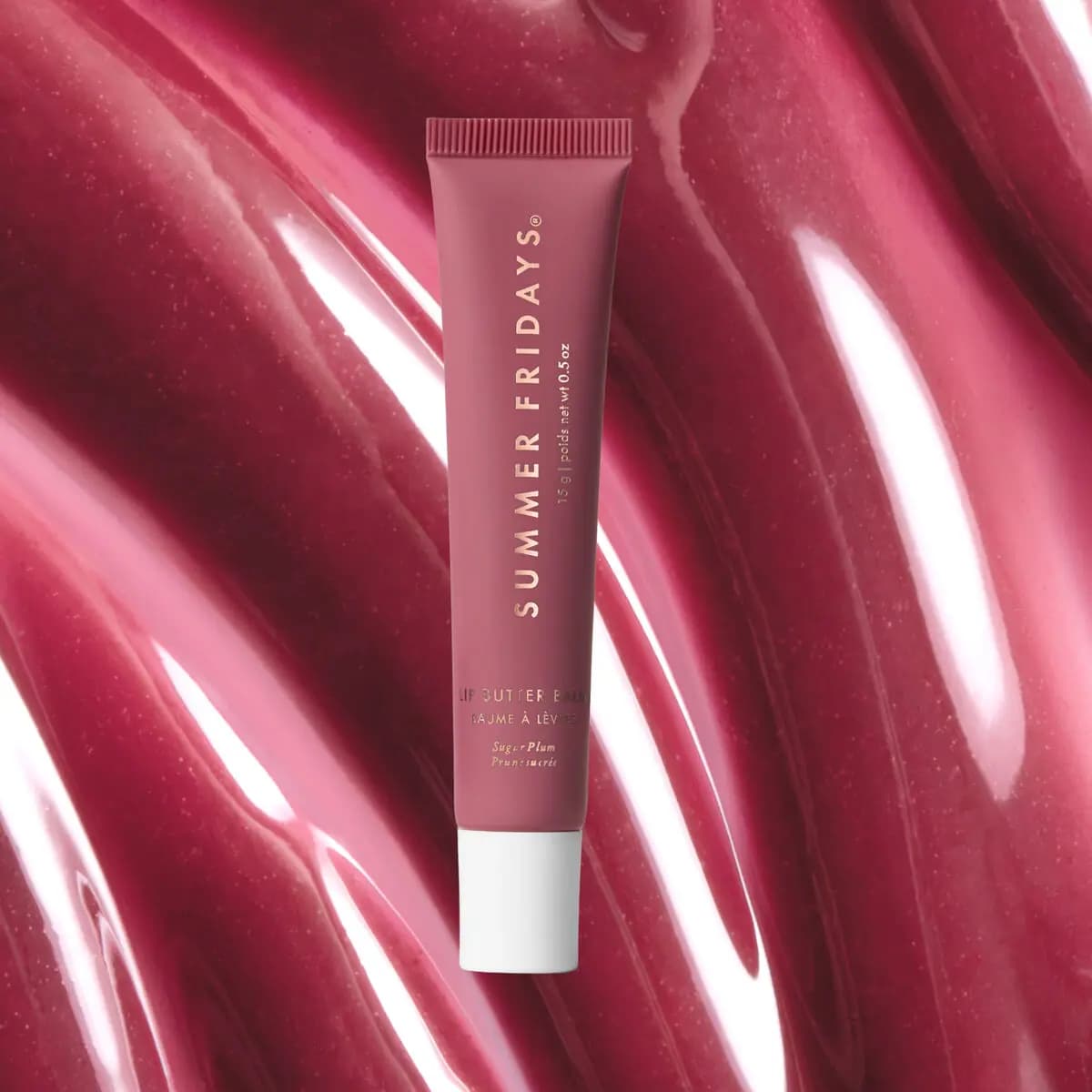 Sugar Plum Lip Butter Balm tube on a glossy smear of sheer berry balm texture