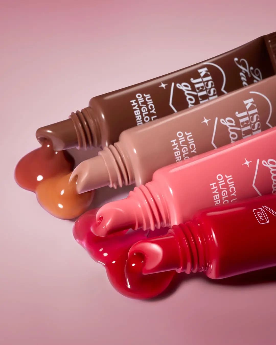 Four Kissing Jelly Gloss tubes in red, pink, nude and brown with glossy product oozing from the tips.