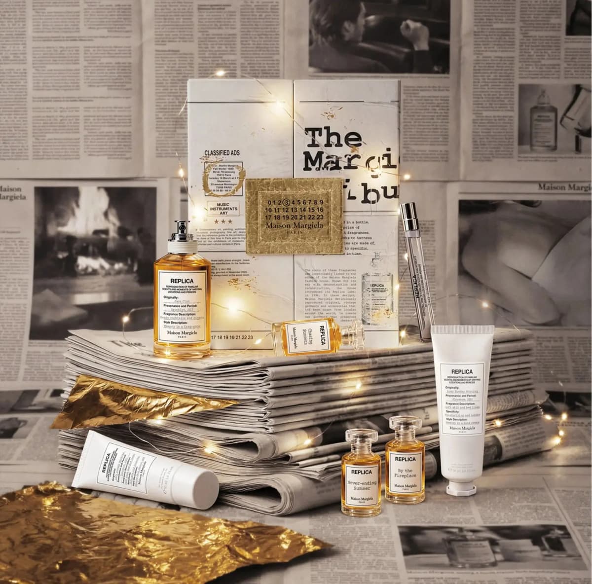 Maison Margiela REPLICA 7-Day Holiday Calendar 2026 with Jazz Club bottle, minis and tubes on newspapers with fairy lights