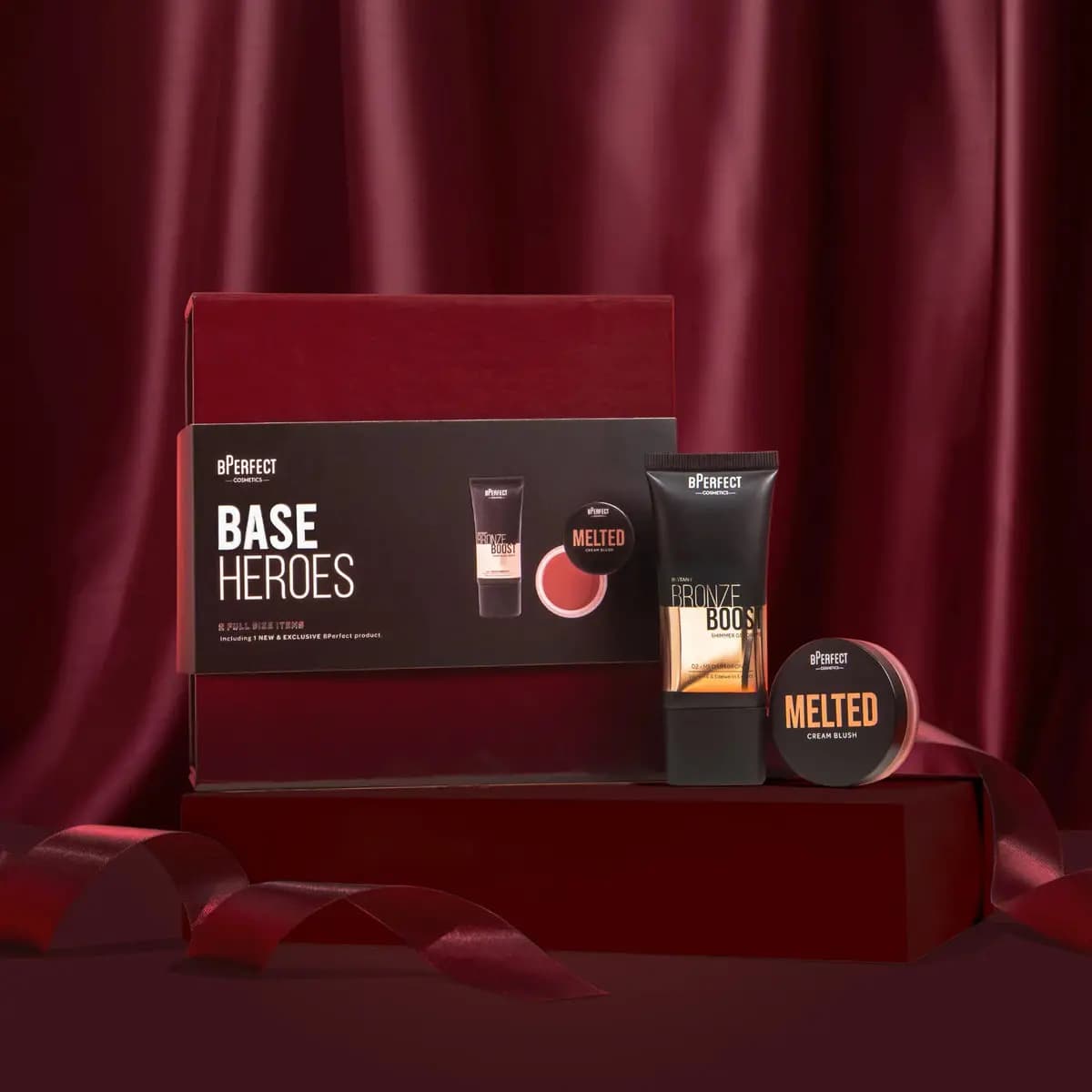 BPerfect Base Heroes box with Instant Bronze Boost shimmer gel tube and Melted cream blush pot on a red plinth