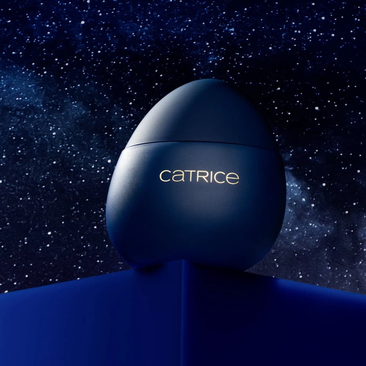 Matte navy egg container lit on a blue plinth against a dark starry night sky