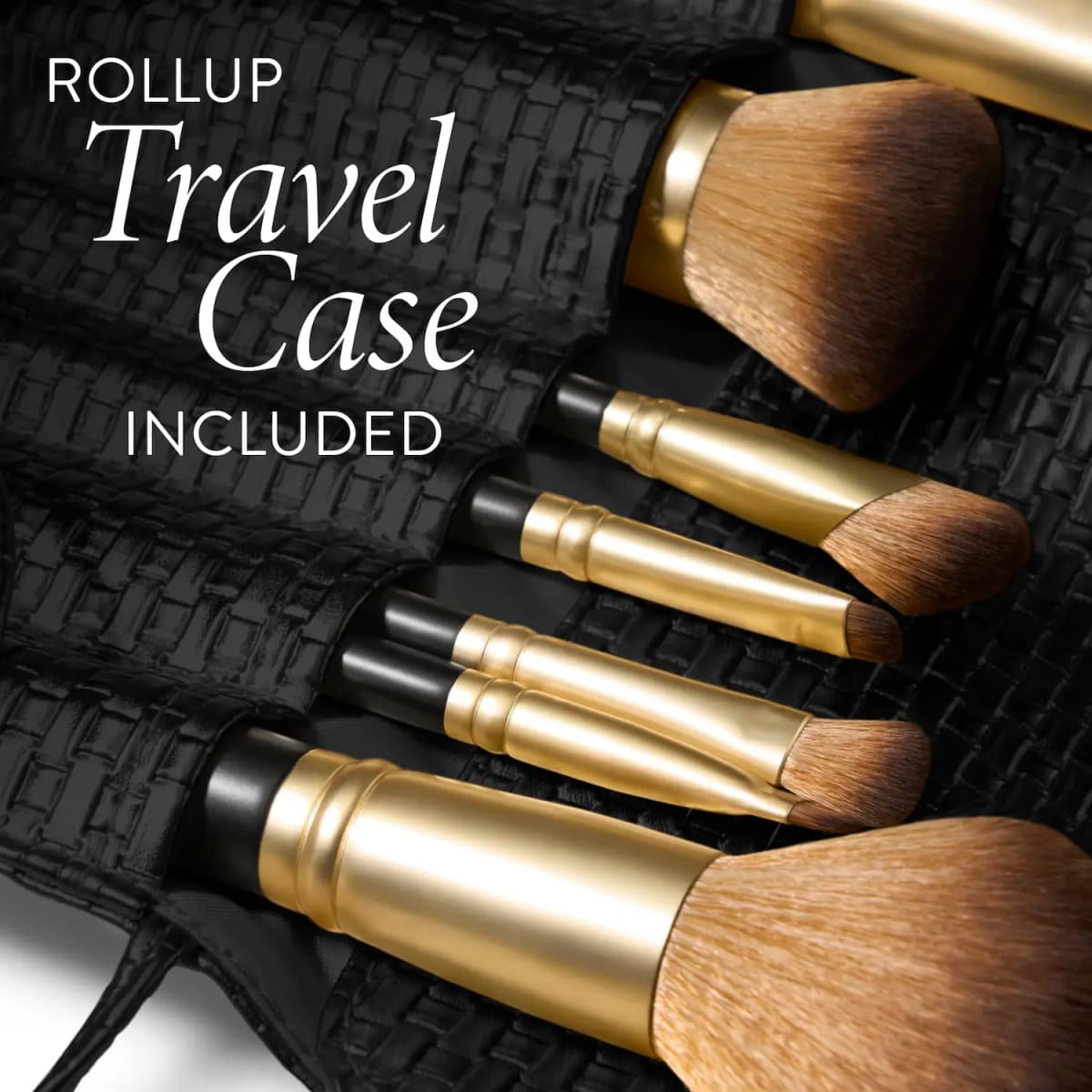 Close-up of gold-ferrule face and eye brushes tucked into a black woven travel case, labelled Rollup Travel Case Included