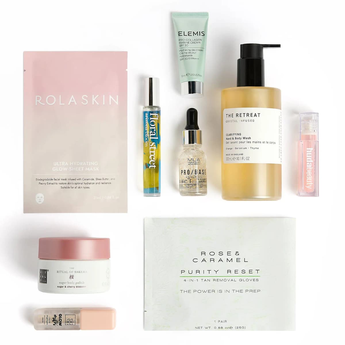 Flat lay of stocking products: Rolaskin mask, Floral Street, Elemis, MUA, The Retreat, Huda Beauty, Rituals and gloves