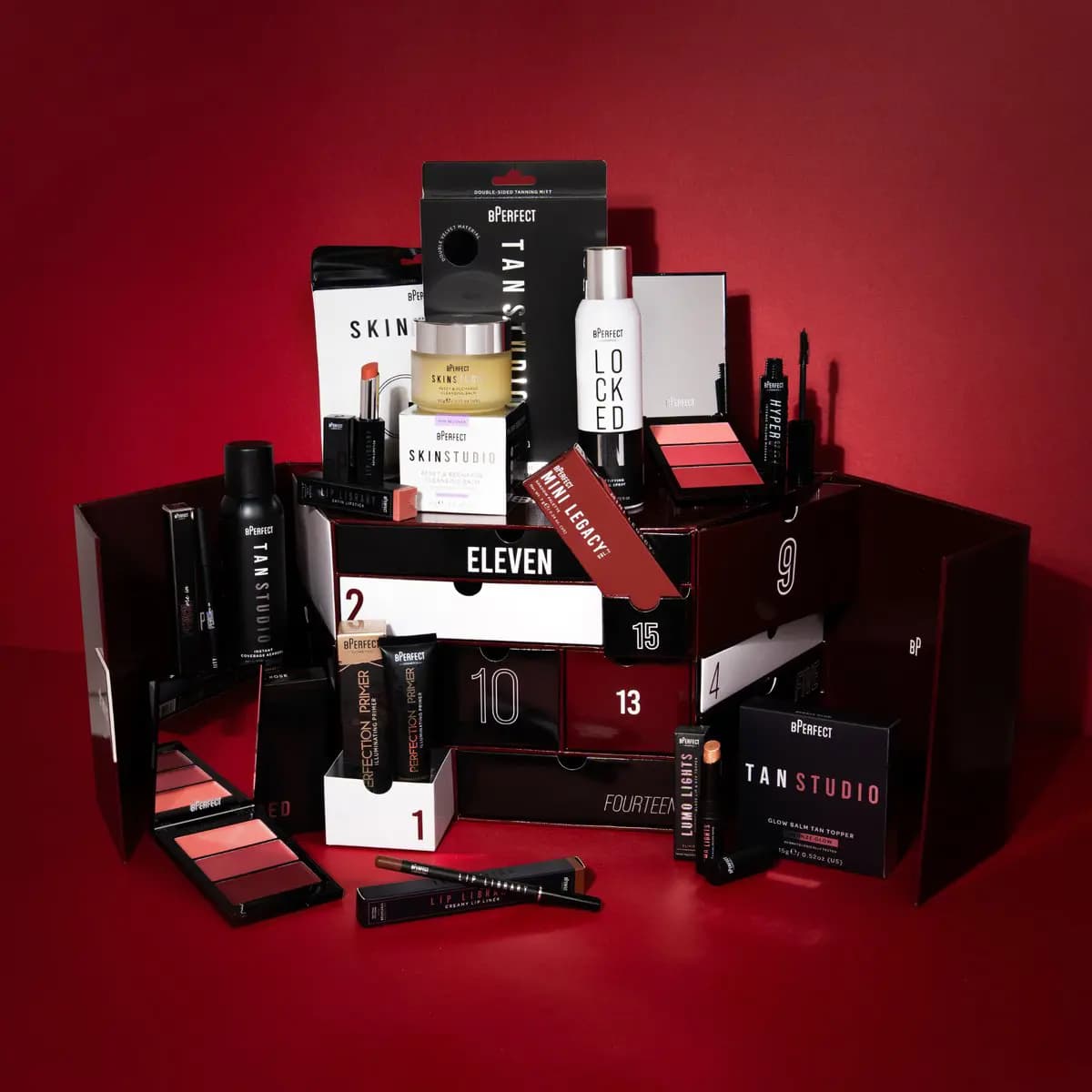 Open BPerfect advent calendar with numbered drawers surrounded by Tan Studio, Skin Studio, Locked In and lip products
