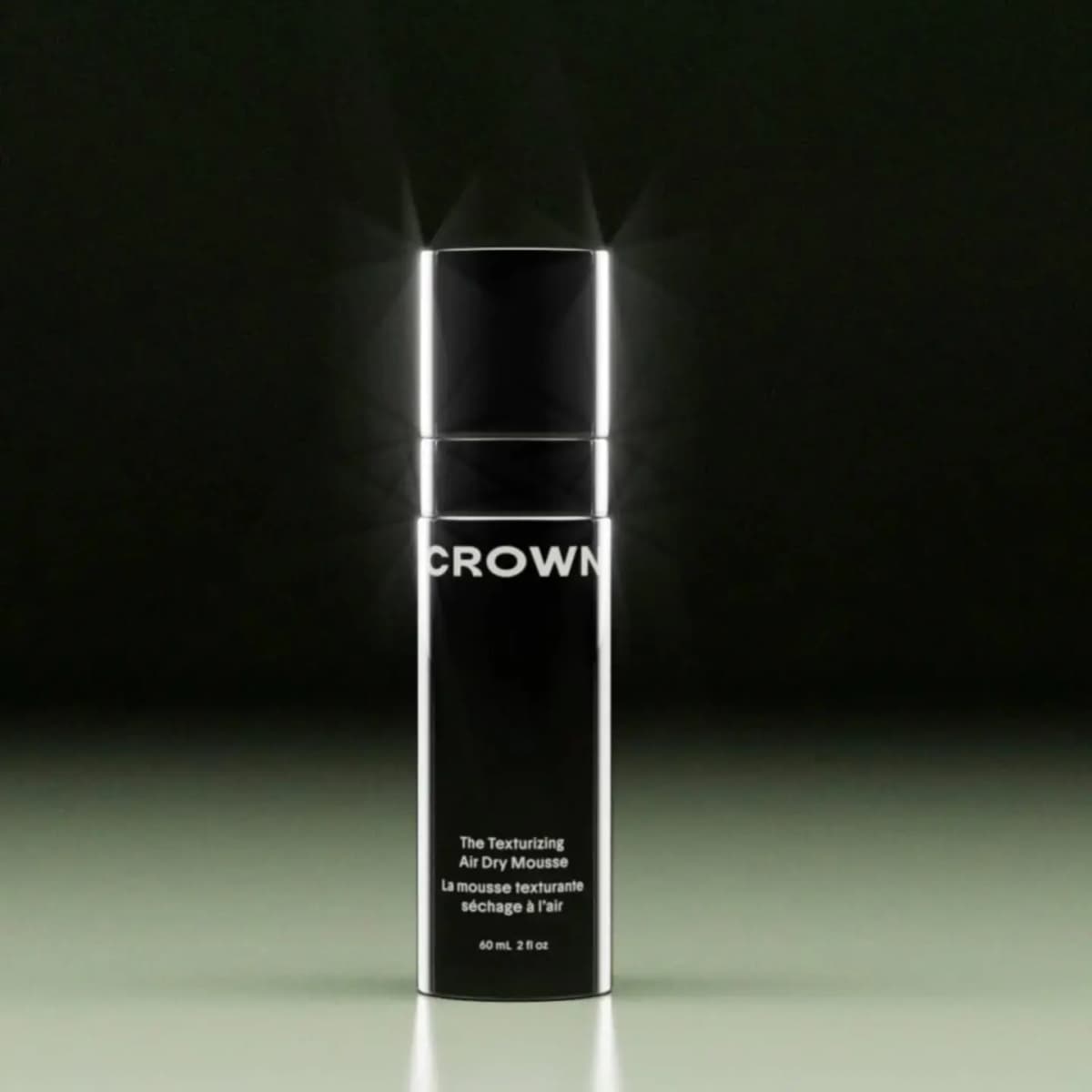 Glossy black Crown The Texturizing Air Dry Mousse bottle, 60 mL, with bright edge highlights on a dark backdrop