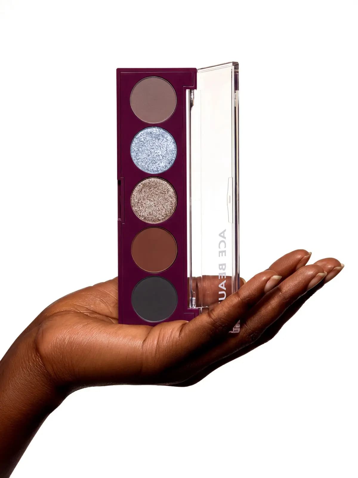Hand holding the open Mini Serenade palette upright, showing Muse, Aura, Noella, Ember and Shadow top to bottom.