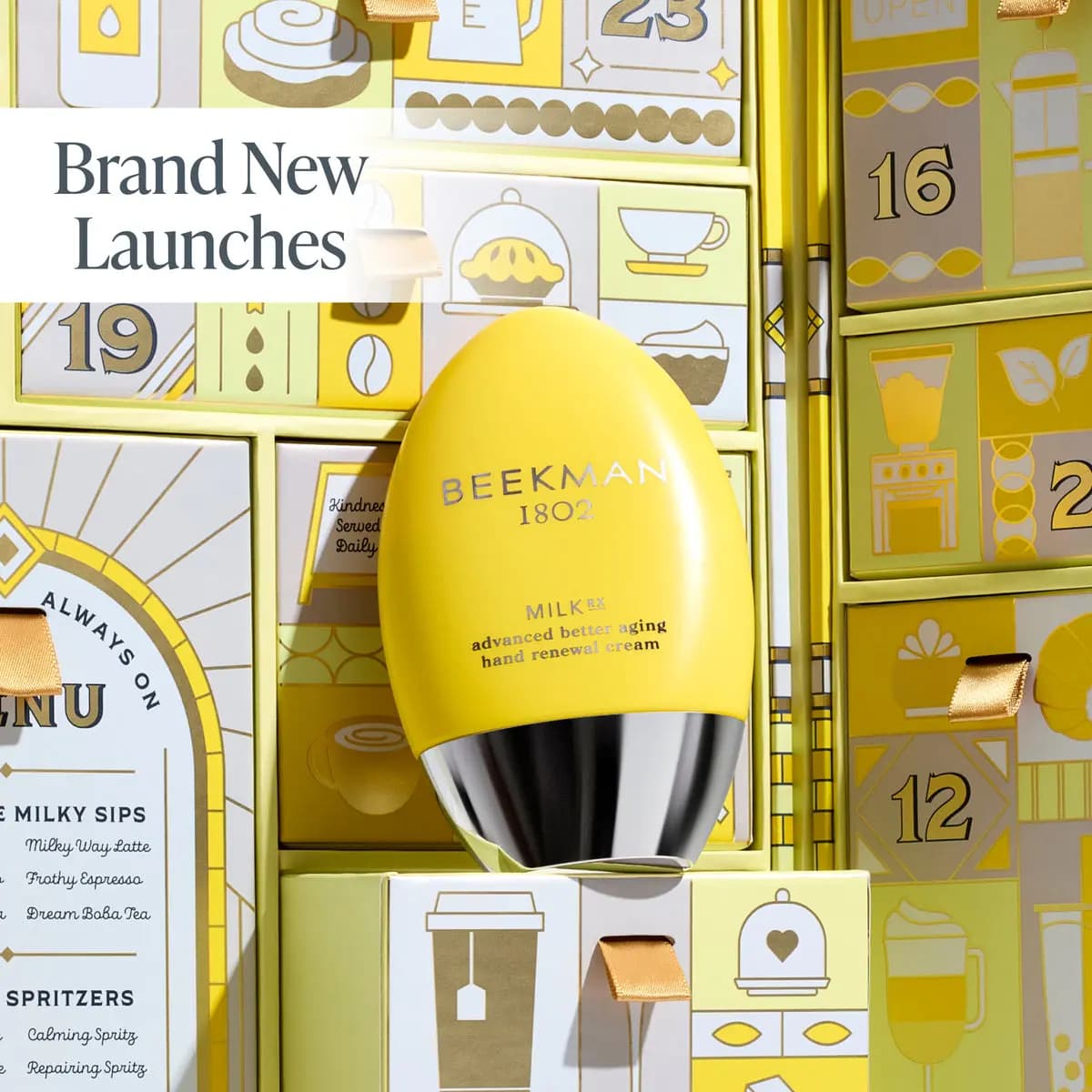 Yellow egg-shaped Beekman 1802 MilkRX hand renewal cream with chrome base against gold-and-yellow numbered drawers