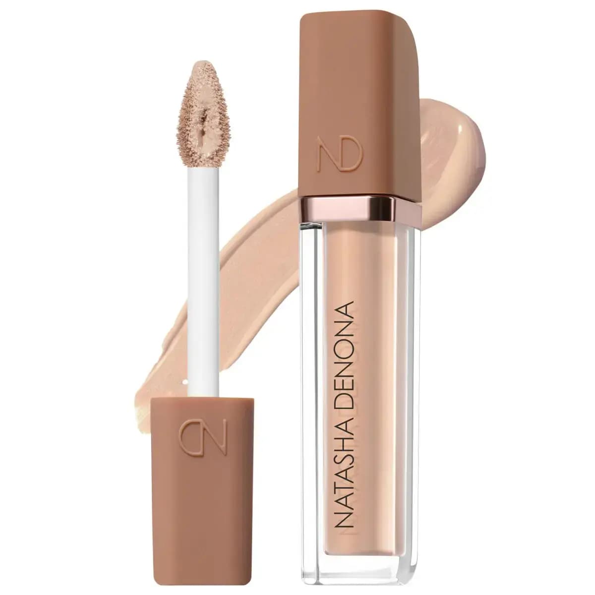 Open concealer tube with tan cap and white wand holding a doe-foot applicator over a light beige swatch.