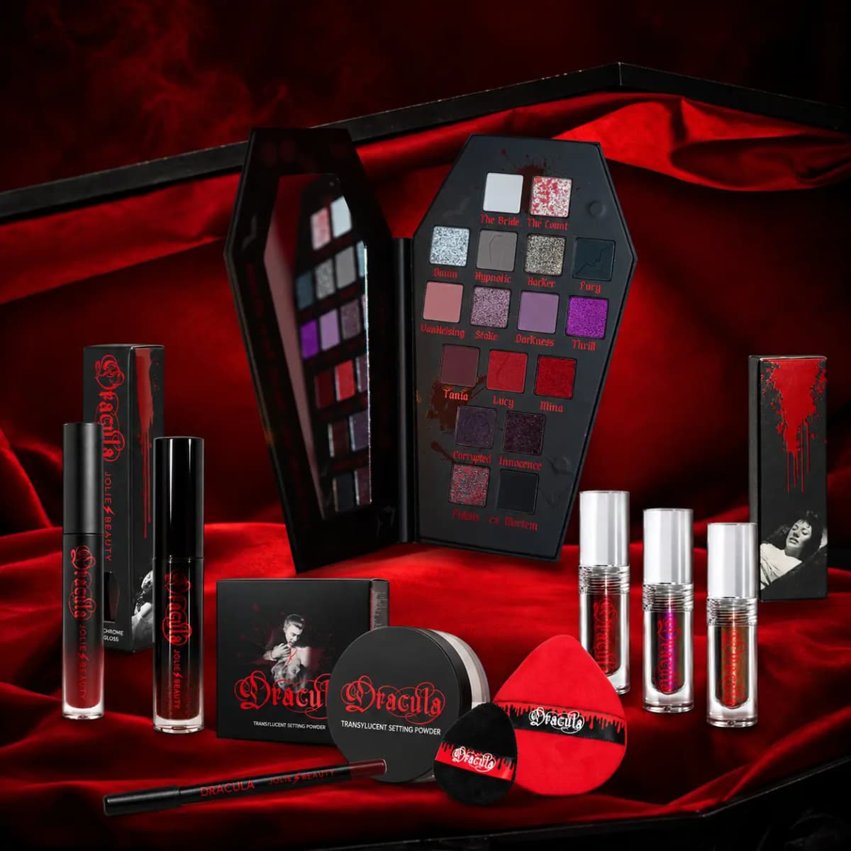 Full collection on red velvet: palette, three liquid eyeshadows, two lip glosses, lip liner, setting powder and puffs