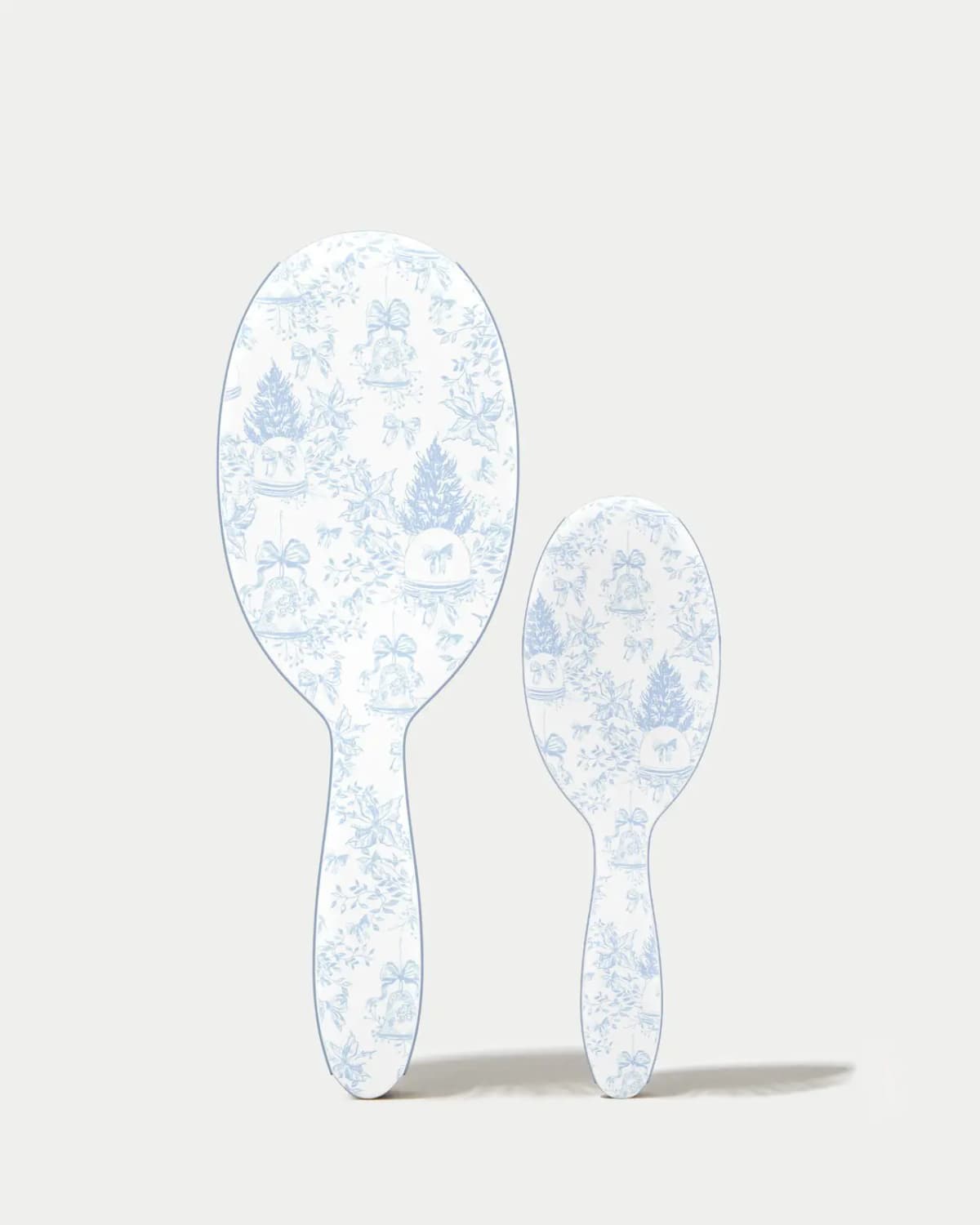 Toile-printed backs of the large and mini brushes, white with blue trees, bells and poinsettias, on grey