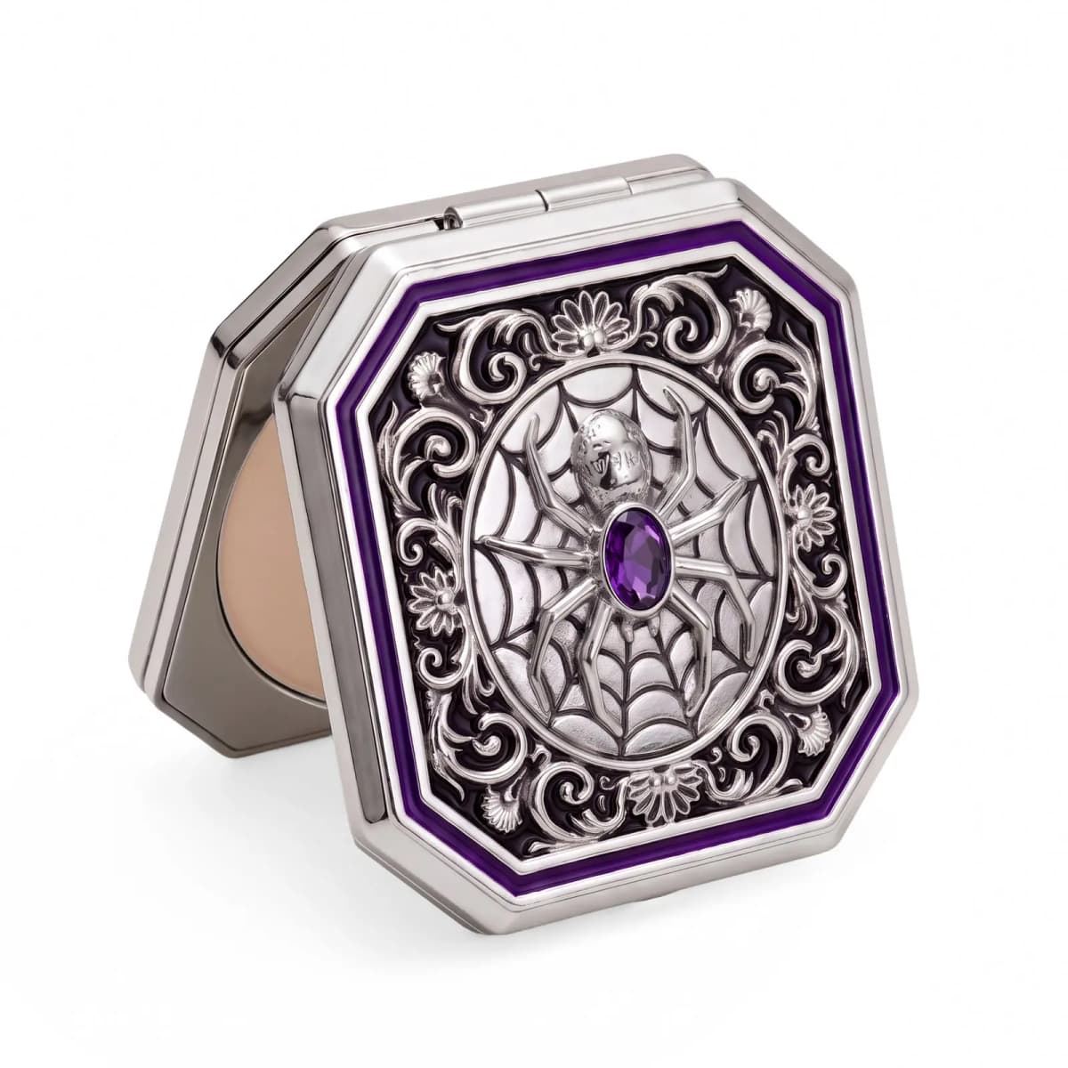 Silver spider compact standing upright, slightly open to show a beige powder pan behind the ornate lid