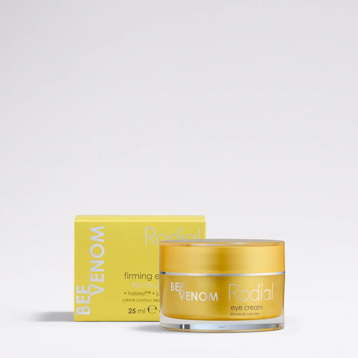 Rodial Bee Venom eye cream in a glossy yellow-gold jar beside its yellow 25 ml box