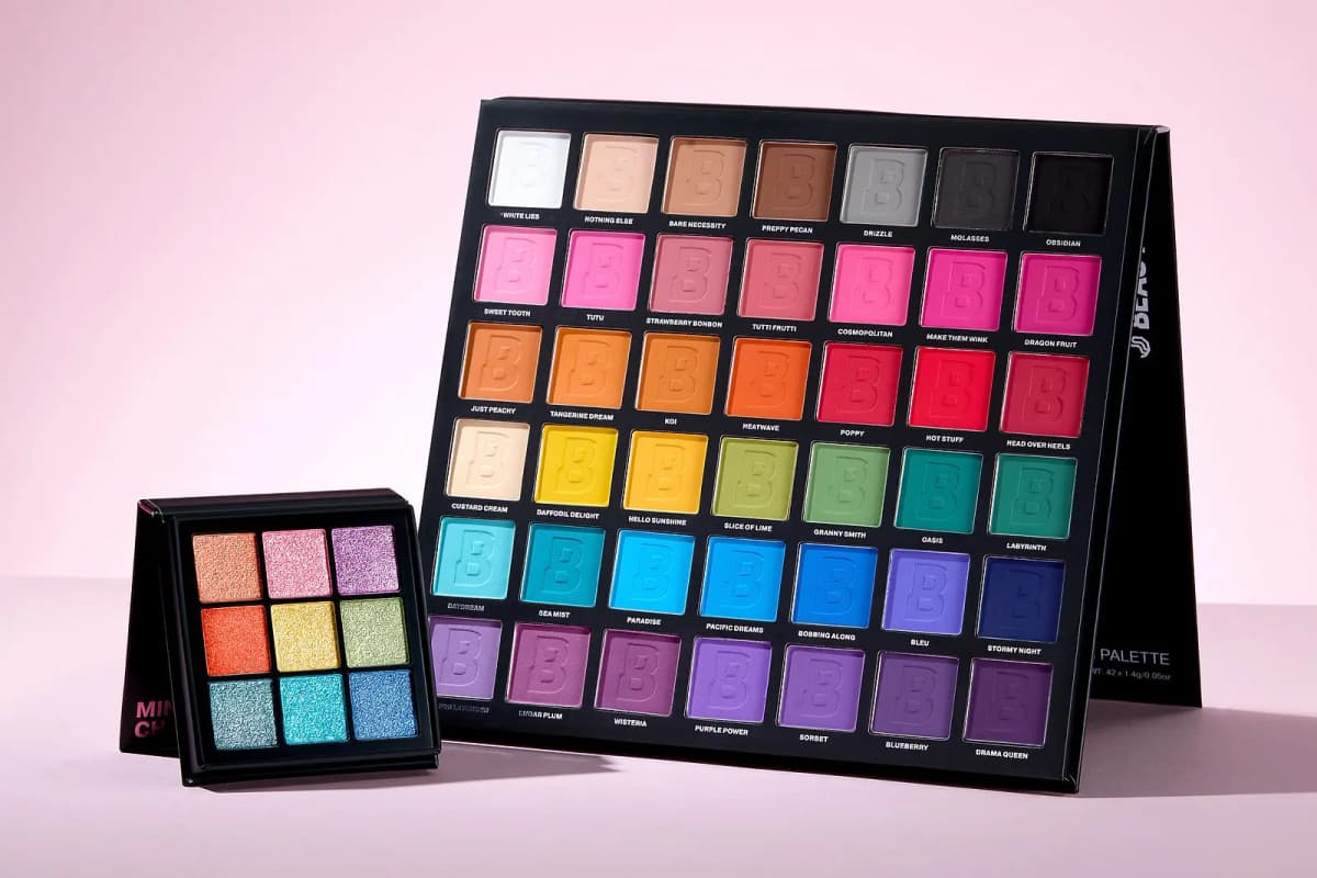 Bright mini shimmer palette beside a large 42-pan matte rainbow eyeshadow palette with labelled shades