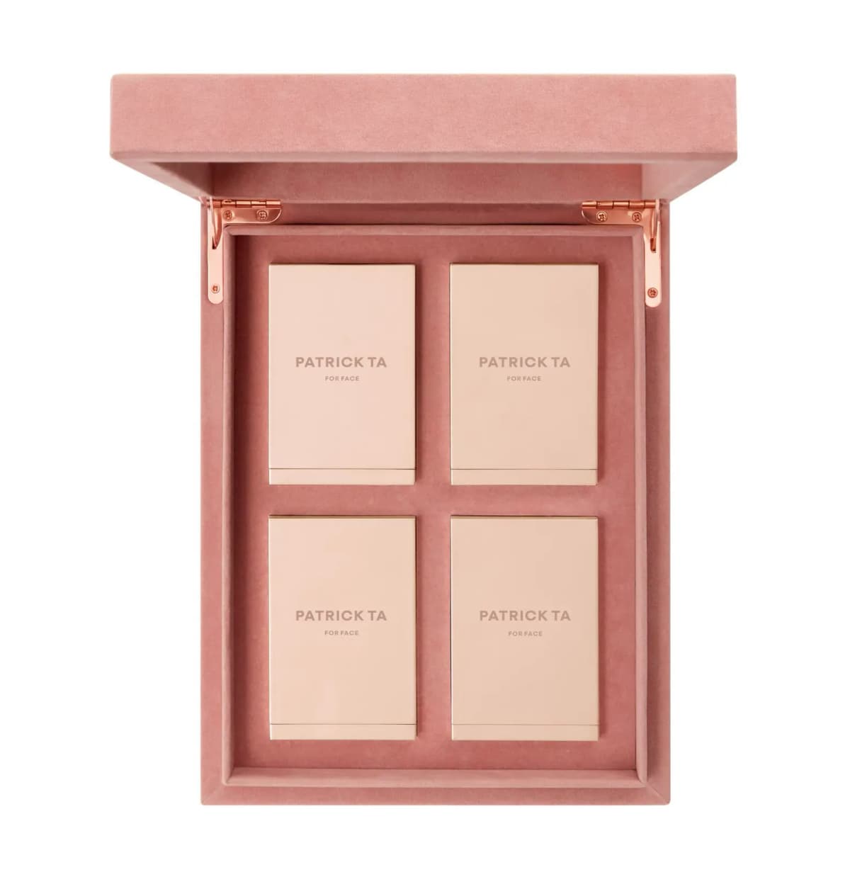 Pink velvet vault with rose-gold hinges and four closed peach Patrick Ta For Face compacts in a two-by-two grid