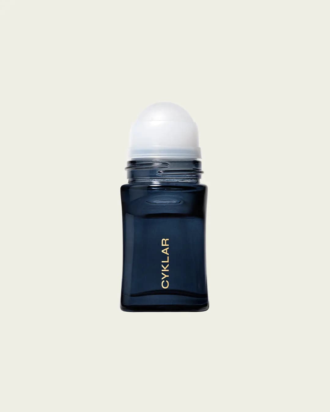 Uncapped navy deodorant bottle showing its white roller ball on a cream background