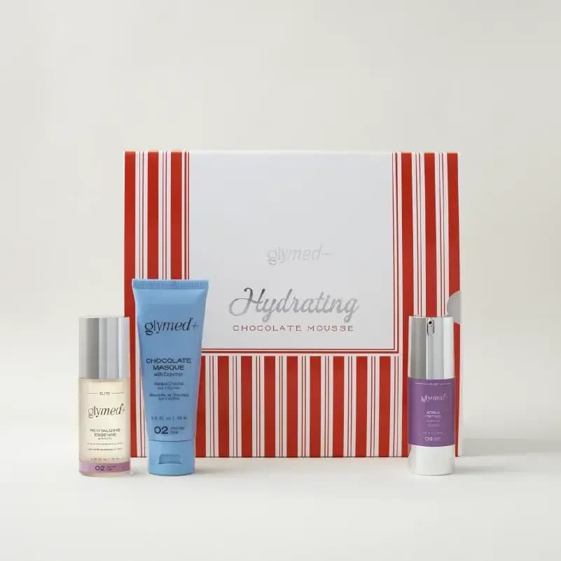 GlyMed+ Hydrating Chocolate Mousse set: essence, Chocolate Masque tube and purple pump before a red-striped box