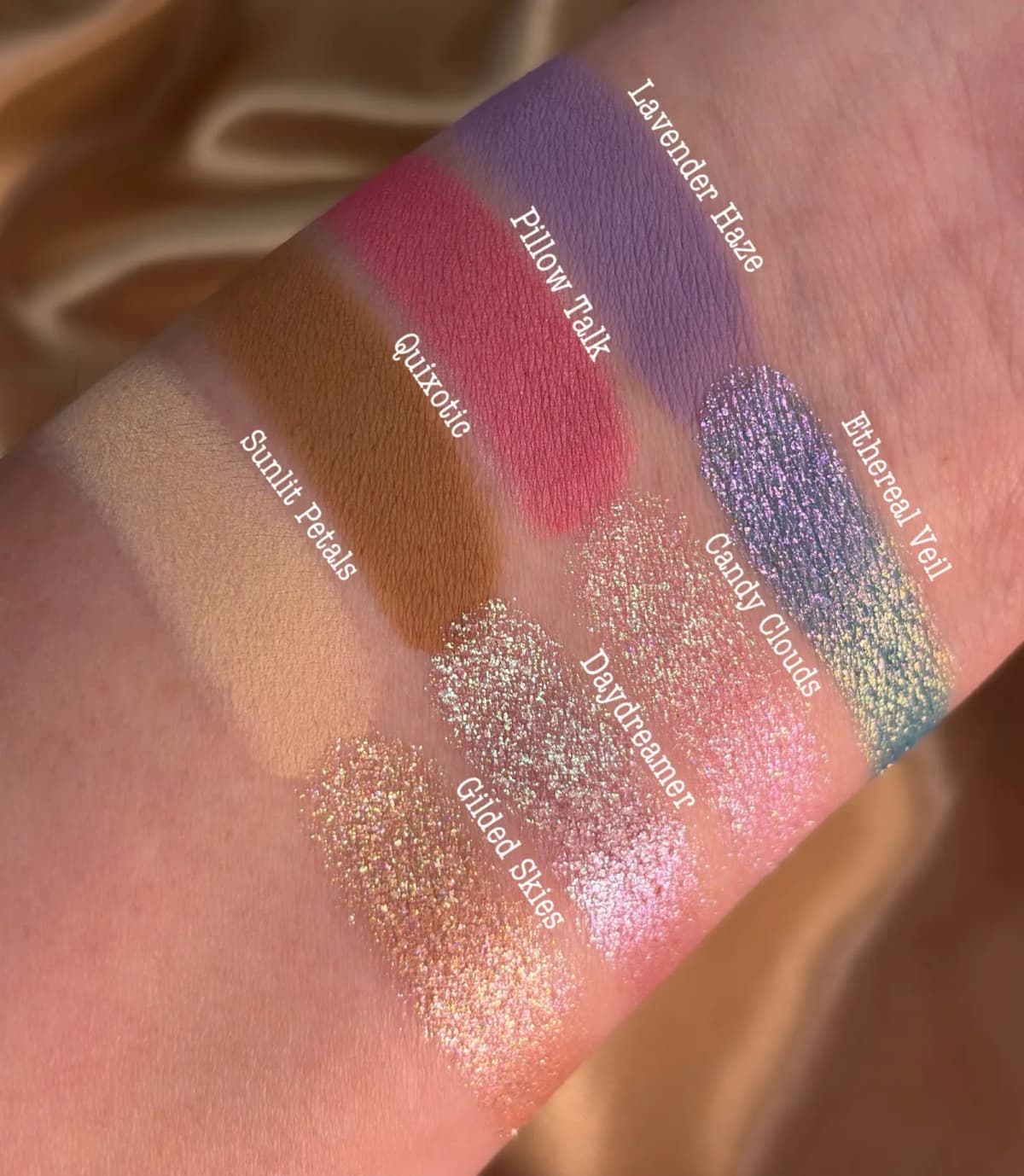 Sunlit arm swatches with labels showing the collection's mattes and shimmers glowing in natural light